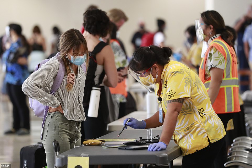 On Monday, a fully vaccinated resident in Hawaii tested positive for the Indian Delta coronavirus variant. Pictured: A traveler is assisted by a state official at the Daniel K. Inouye International Airport in Honolulu, Oahu